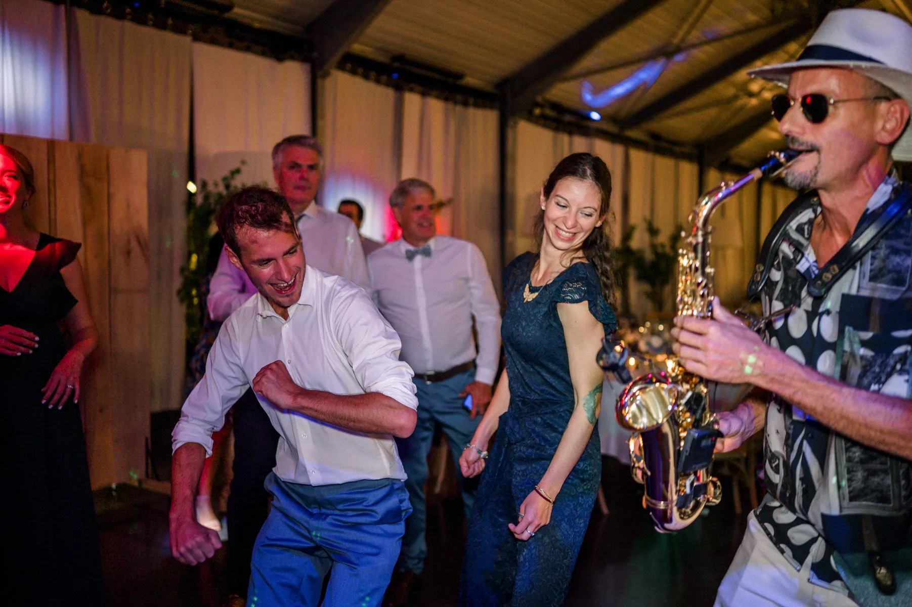 Guests dancing around saxophonist mikOsax during the dance set of a private party