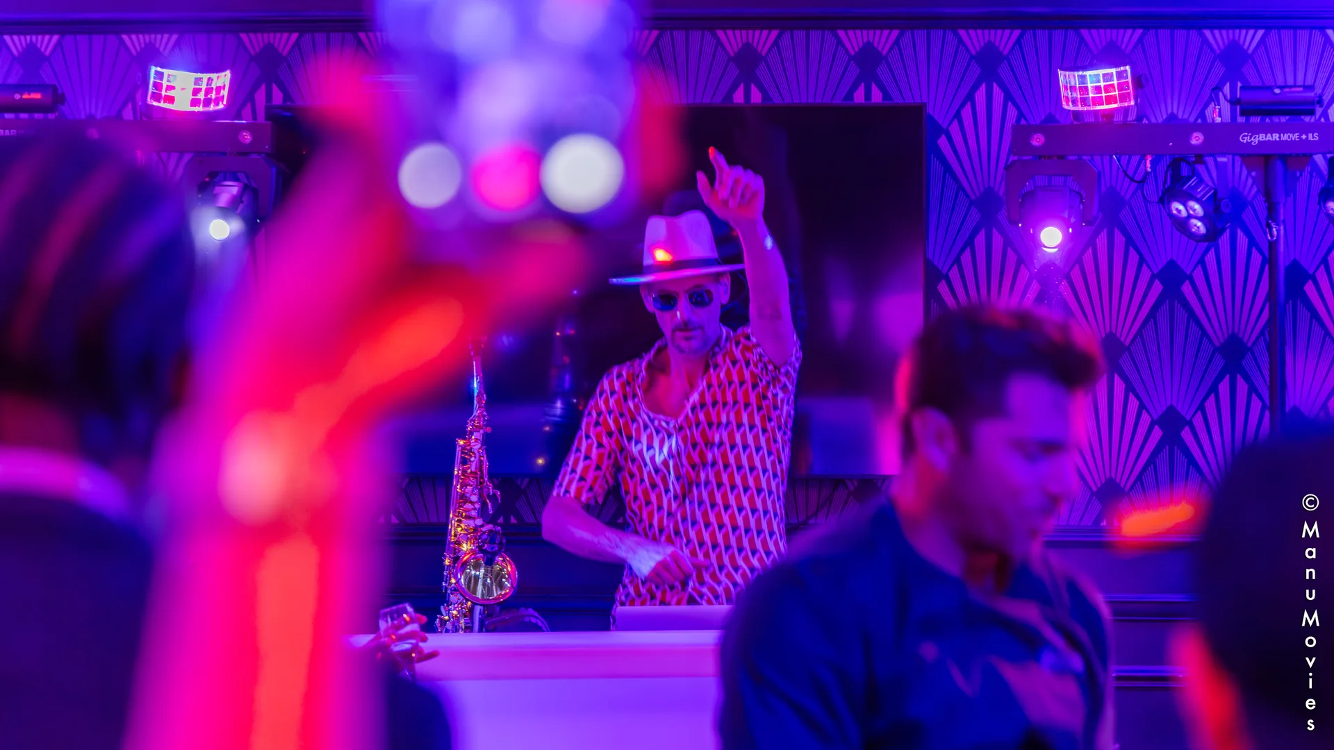 mikOsax performing a DJ sax set behind the decks at a chic Art Deco party